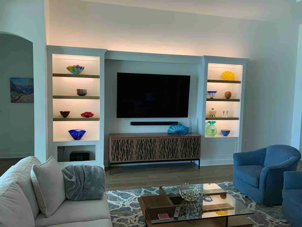 Built-in media wall with lit display shelves and a media console