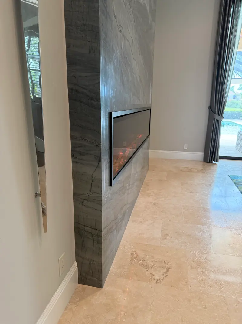 Side view showing the depth of a floor-to-ceiling granite fireplace wall