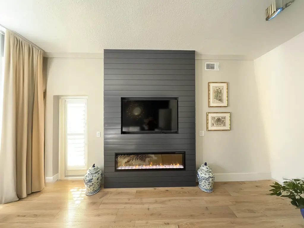 Charcoal horizontal shiplap fireplace wall with a recessed TV and linear electric fireplace