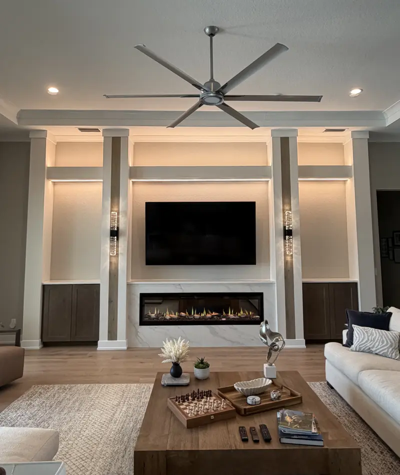 White built-in media wall with lit columns and a linear electric fireplace