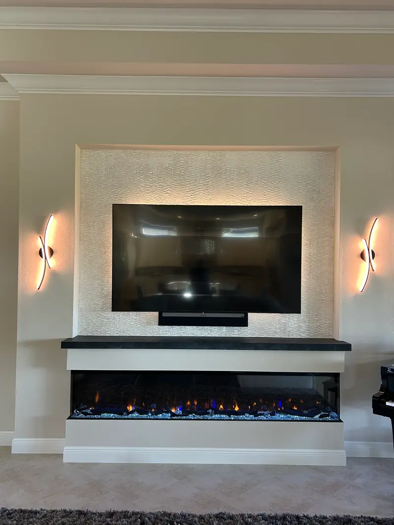 Recessed plaster niche with wall sconces, a floating mantel and a three-sided electric fireplace
