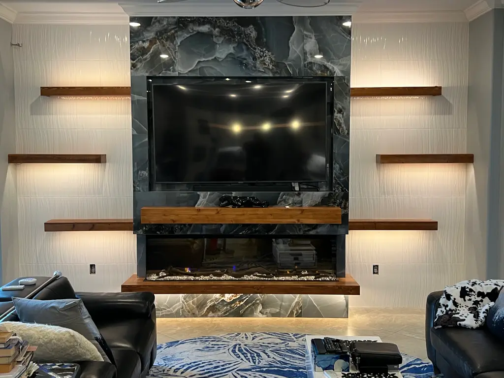 Blue onyx feature wall with a live-edge wood mantel, lit floating shelves and a wide electric fireplace