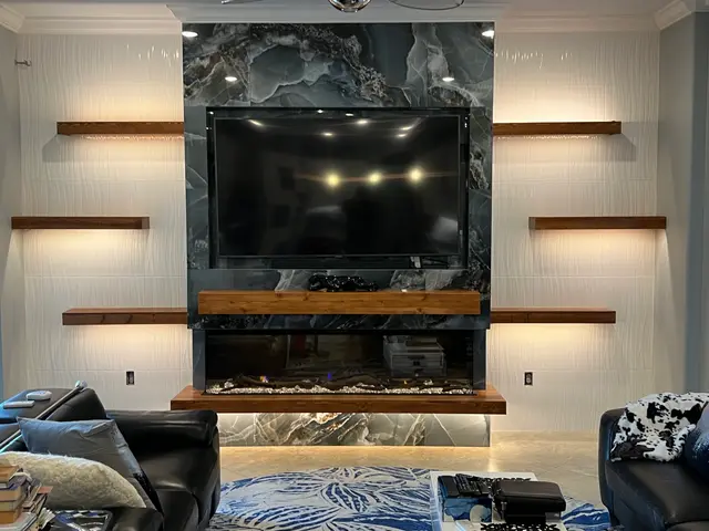 Blue onyx feature wall with a live-edge wood mantel and lit floating shelves
