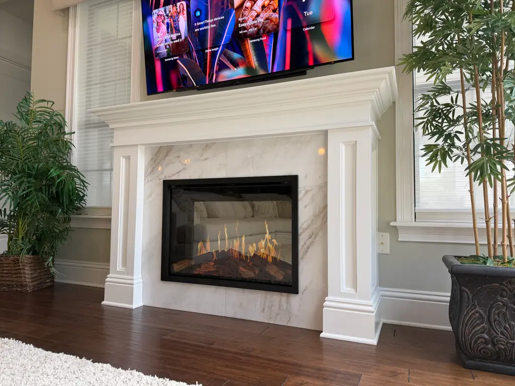 Traditional white mantel with a marble surround and an electric fireplace