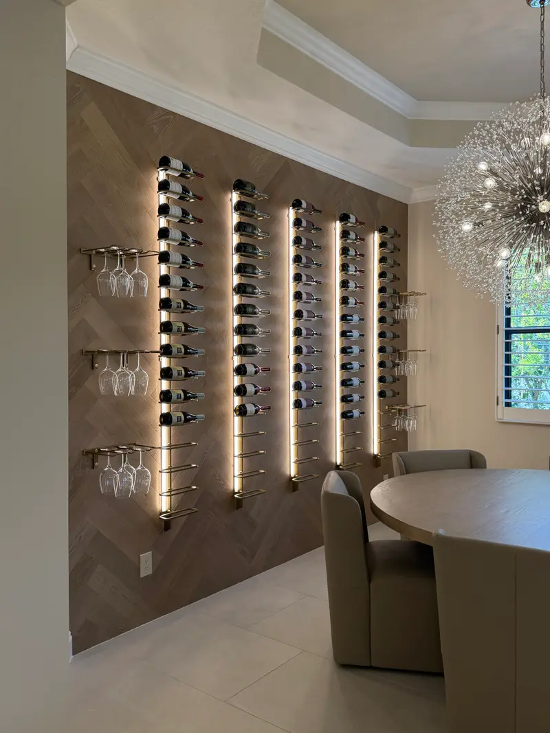 Herringbone wood wine wall with vertical LED-lit bottle racks and glass holders